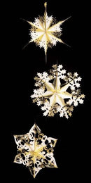 Three hanging decorative snowflake and star ornaments in metallic gold and white, displayed against a solid black background.