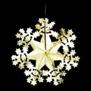 A hanging snowflake-shaped Christmas ornament made of layered star and snowflake cutouts in white and metallic gold, shown against a solid black background.